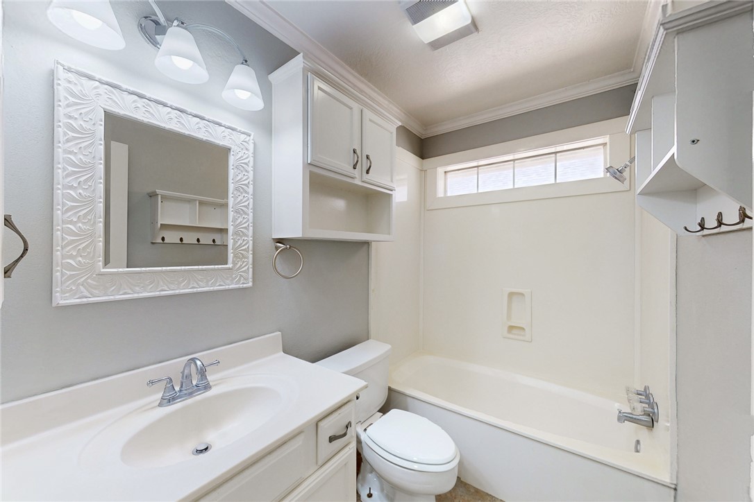 2817 Brandywine Circle Bryan, TX 77807 - Photo 23 of 28 a bathroom with a bathtub shower sink vanity mirror and toilet
