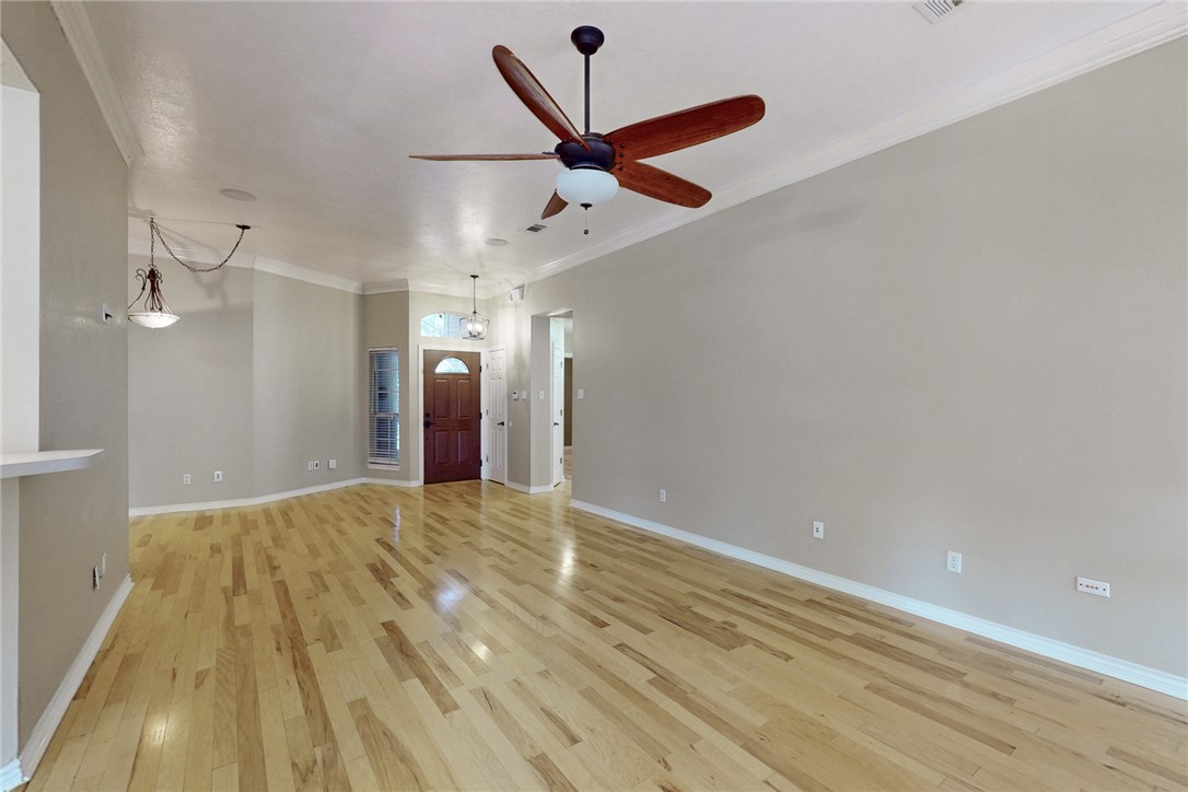 2817 Brandywine Circle Bryan, TX 77807 - Photo 6 of 28 wooden floor in an empty room with a ceiling fan