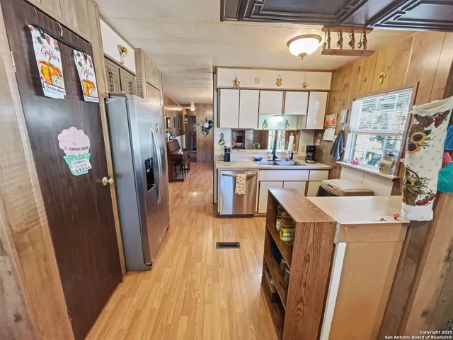 a kitchen with stainless steel appliances a sink a refrigerator a stove and a refrigerator