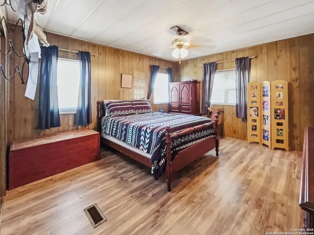 a spacious bedroom with a bed and a chandelier