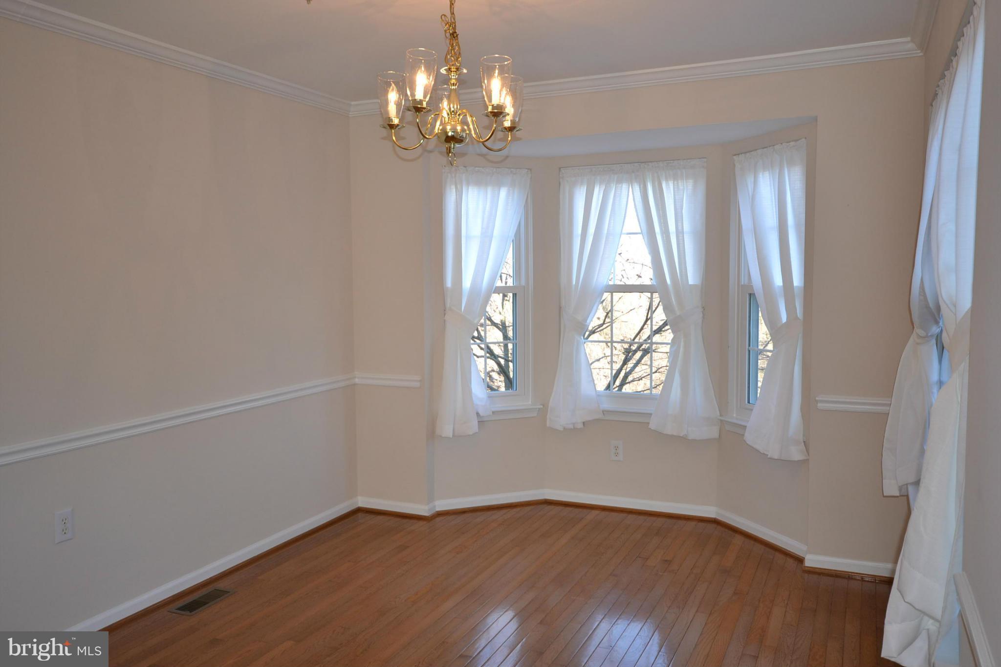 2629 Caulfield Court Frederick, MD 21701 - Photo 5 of 17 a view of an empty room with wooden floor and a window
