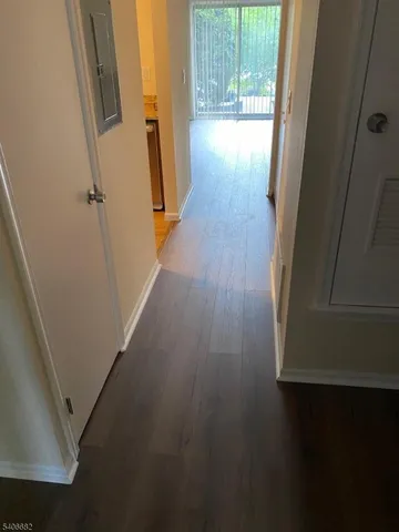 a view of a hallway with wooden floor and stairs