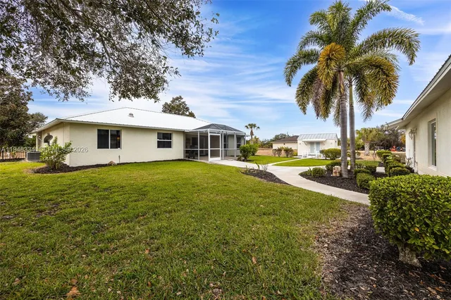 a view of a house with a big yard and large trees
