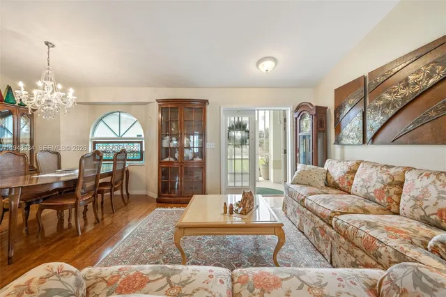 a living room with furniture a dining table and a large window