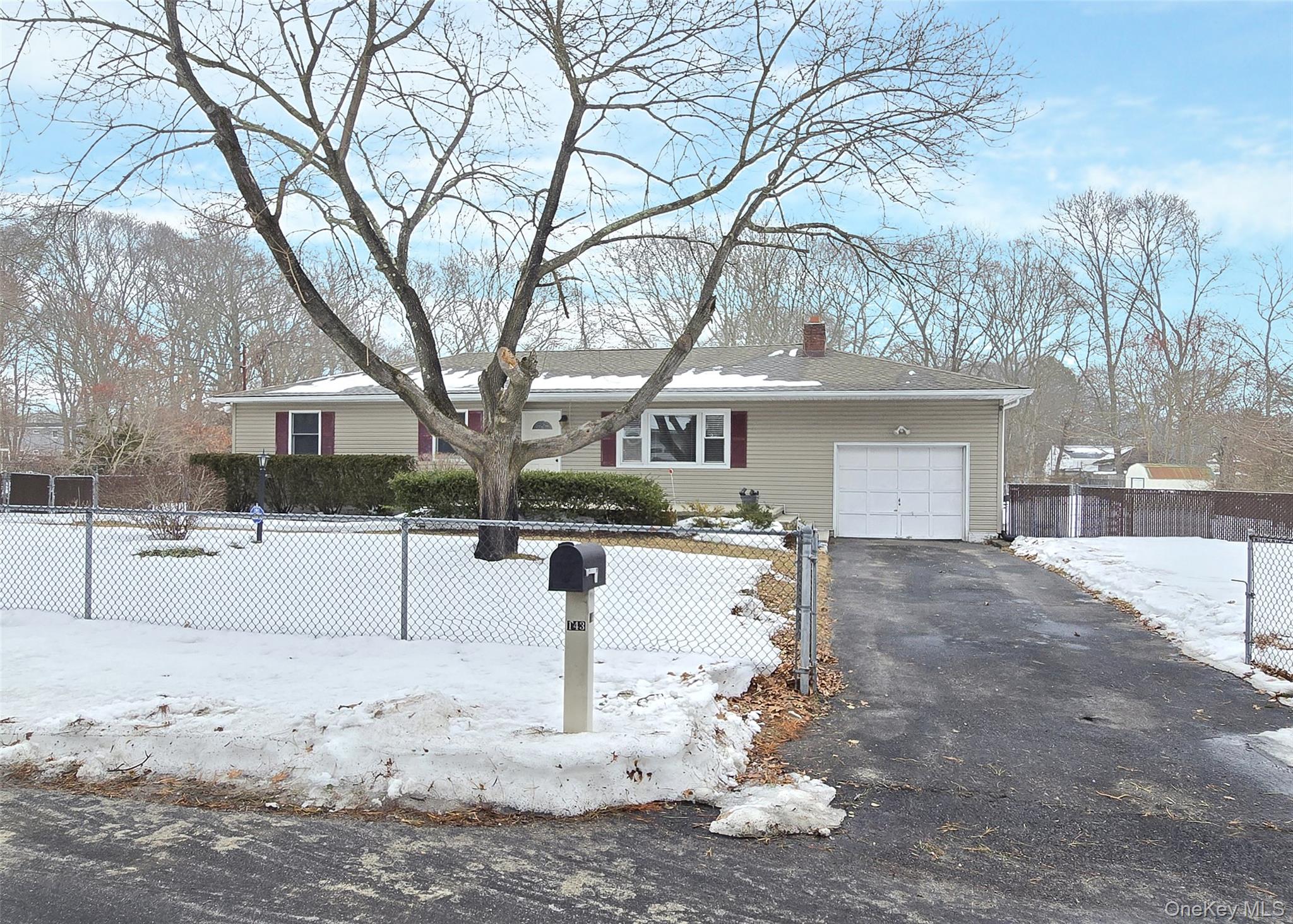 a front view of a house with a yard covered in snow
