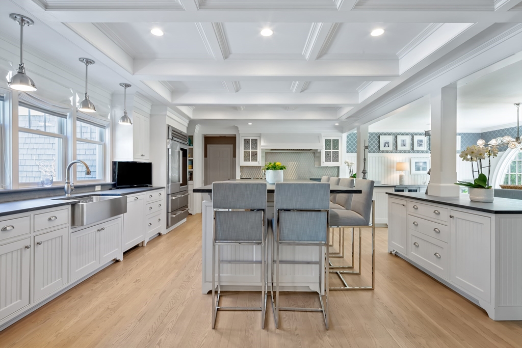 207 Pineleigh Path Barnstable, MA 02655 - Photo 19 of 42 a large open kitchen with granite countertop a stove a sink a dining table and chairs