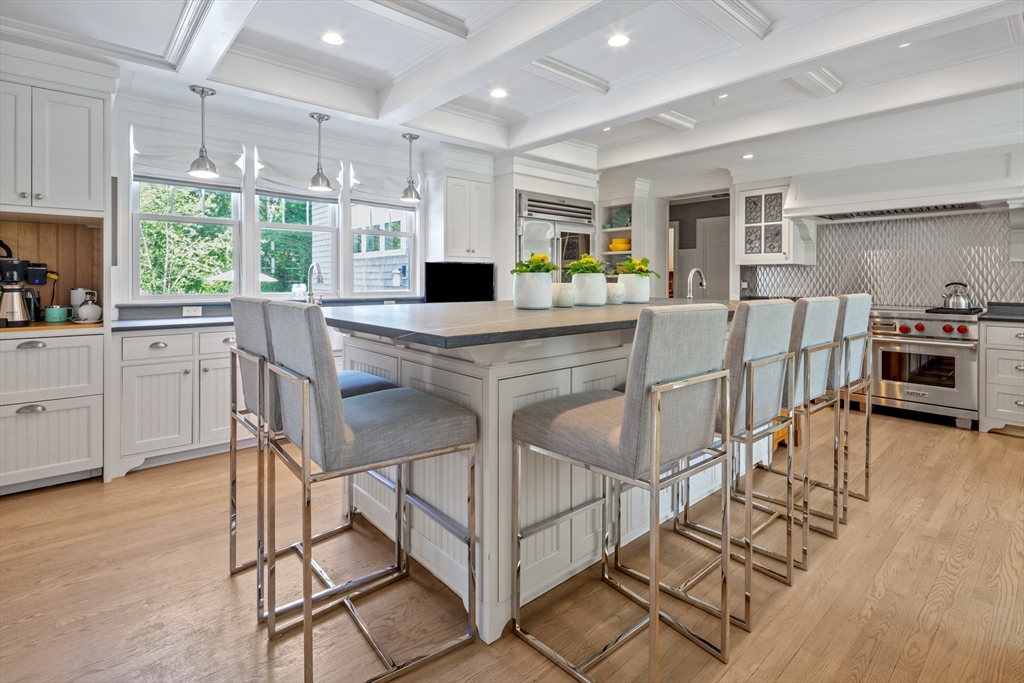 207 Pineleigh Path Barnstable, MA 02655 - Photo 21 of 42 a kitchen with stainless steel appliances kitchen island granite countertop a table chairs sink and cabinets