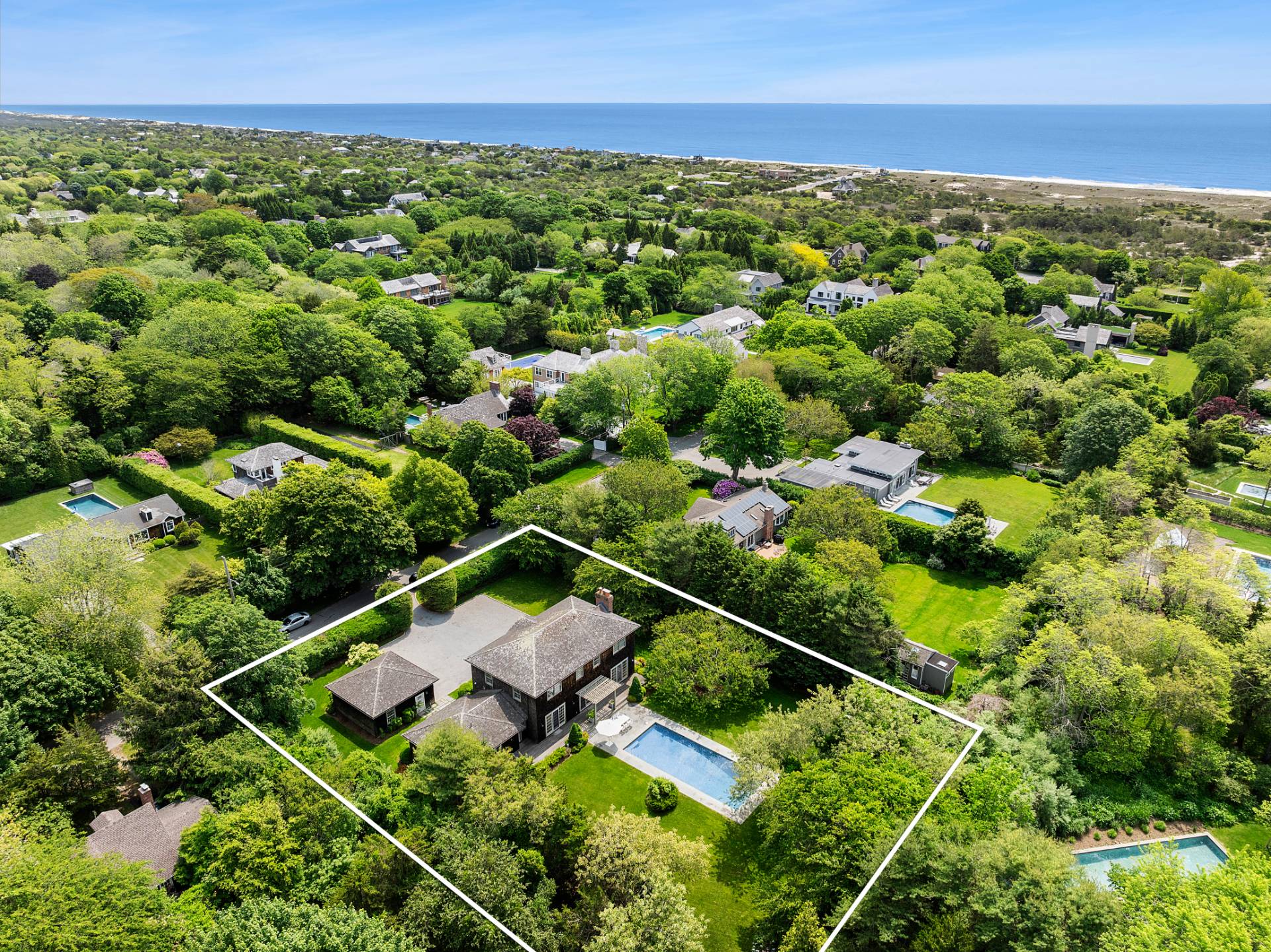 an aerial view of residential houses with outdoor space and trees