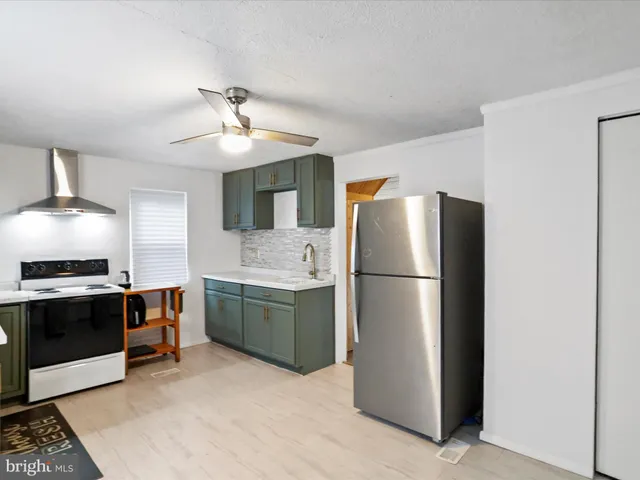 a kitchen with kitchen island a sink stove and refrigerator