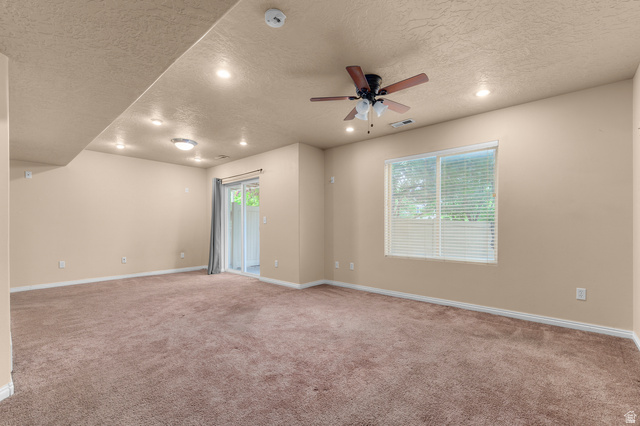3053 Sage Loop, Unit B1 Lehi, UT 84043 - Photo 19 of 25 Spacious room featuring neutral carpet flooring, recessed lighting, a ceiling fan, a window with blinds, and a sliding glass door