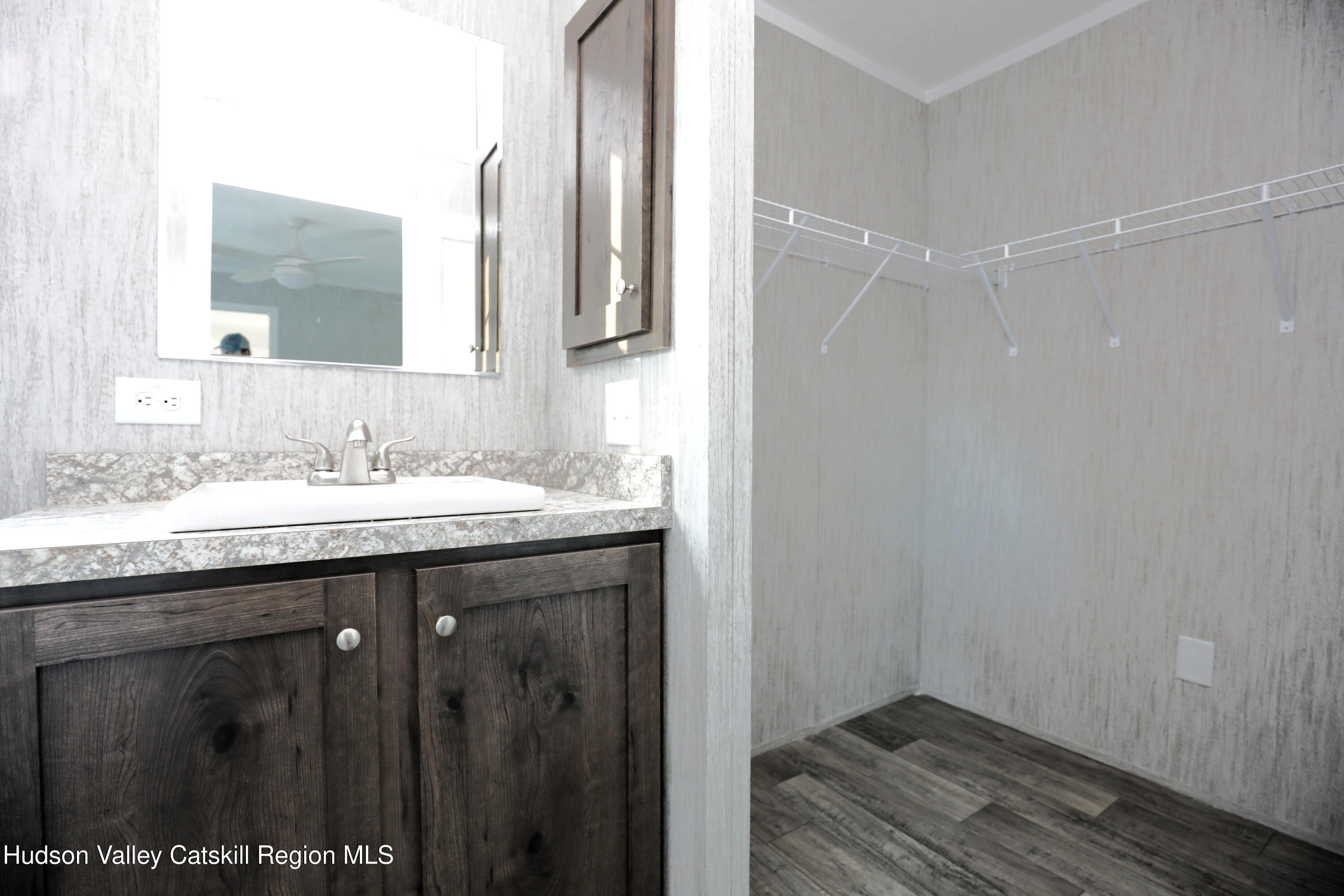 414 Joslen Boulevard, Unit 24 Hudson, NY 12534 - Photo 5 of 9 a bathroom with a granite countertop sink a mirror and a shower