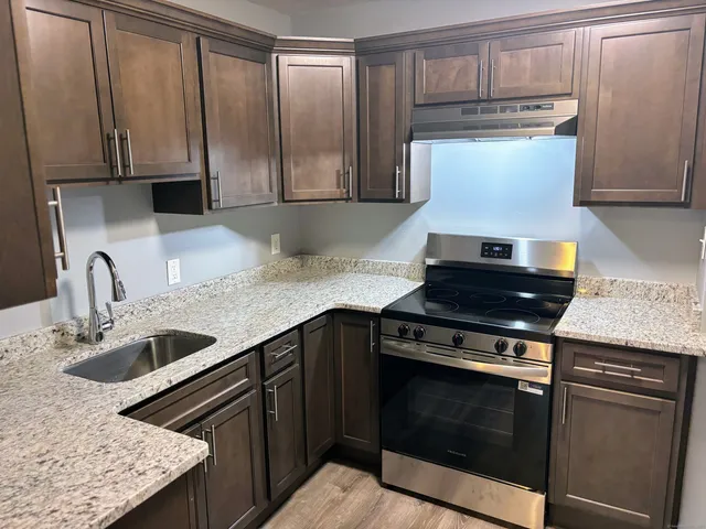a kitchen with granite countertop a stove and a sink
