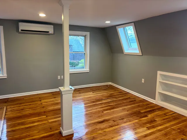 a view of empty room with window and wooden floor