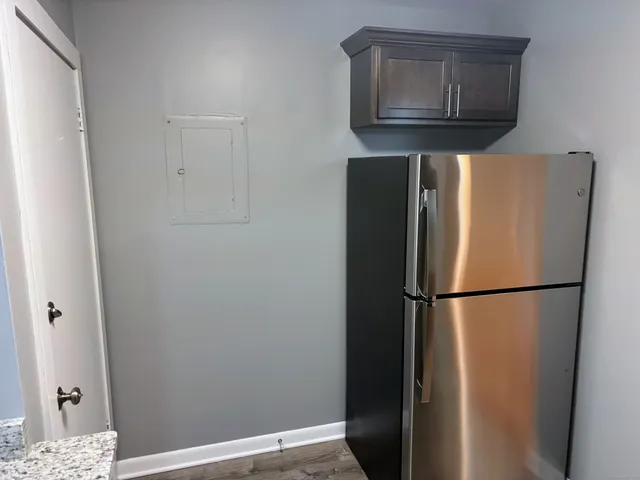 a white refrigerator freezer and a wooden floor