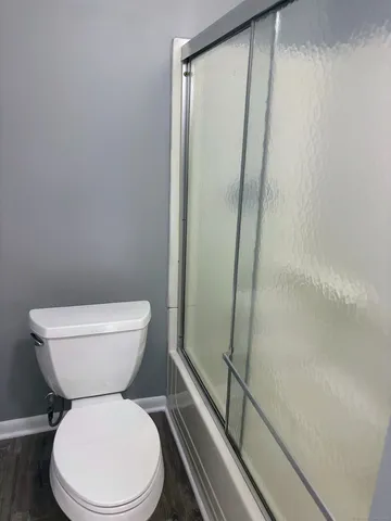 a white toilet sitting next to a shower