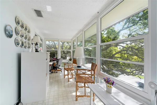 a dining room with furniture water view and a floor to ceiling window