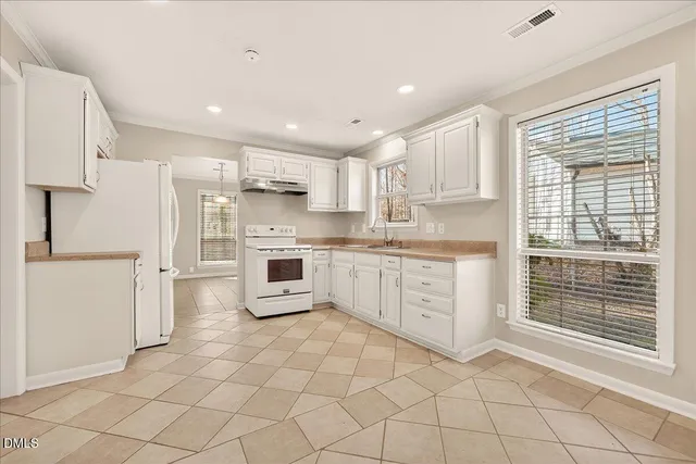 a kitchen with white cabinets and white appliances