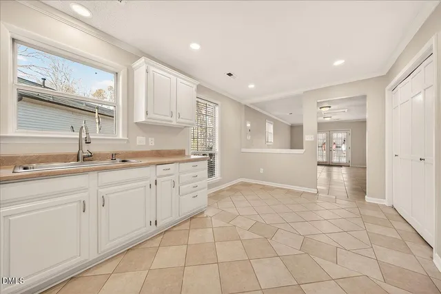 a kitchen with white cabinets stainless steel appliances and sink