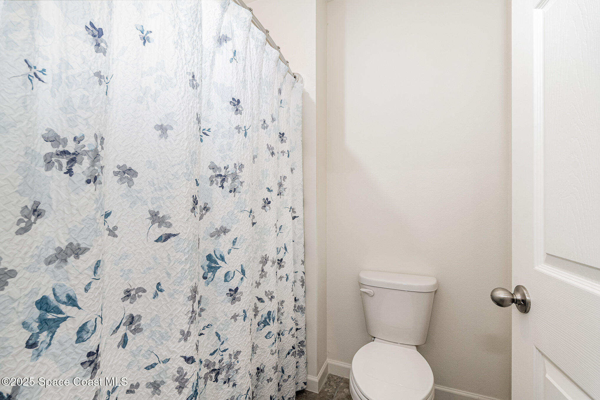 735 Sorrento Drive Cocoa, FL 32922 - Photo 13 of 23 a white toilet sitting next to a shower curtain