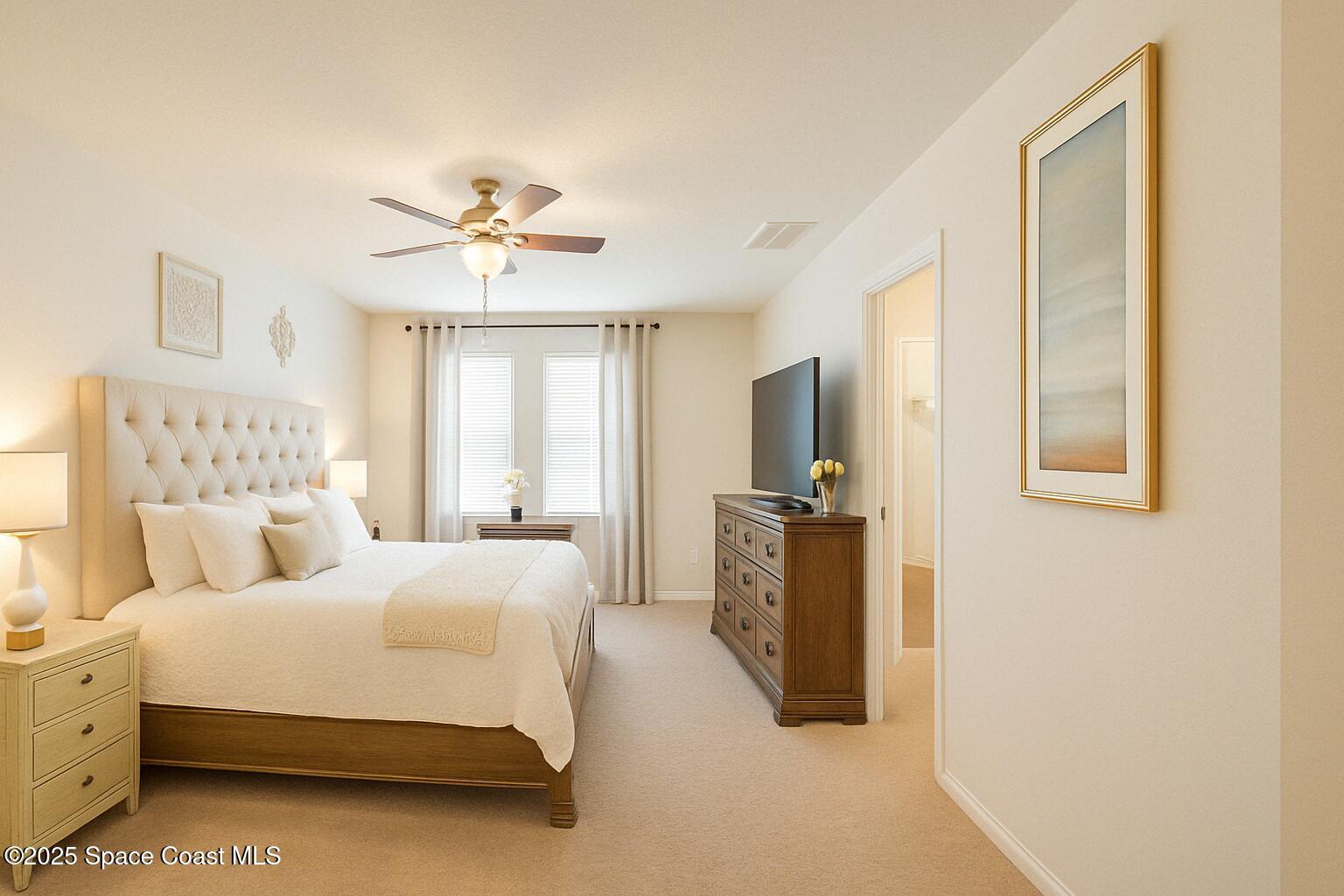 735 Sorrento Drive Cocoa, FL 32922 - Photo 10 of 23 a spacious bedroom with a bed and a chandelier