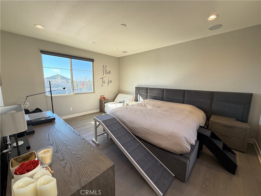 101 Interval Irvine, CA 92618 - Photo 7 of 20 a bedroom with a bed and wooden floor