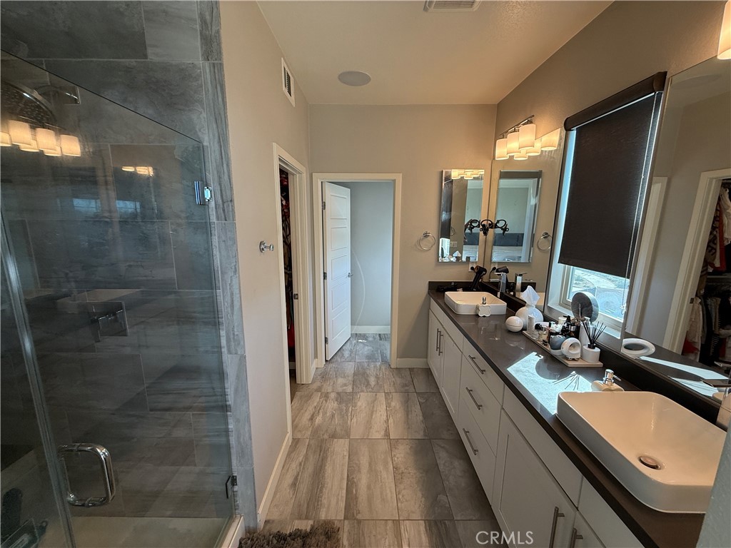 101 Interval Irvine, CA 92618 - Photo 9 of 20 a bathroom with a double vanity sink a mirror and shower