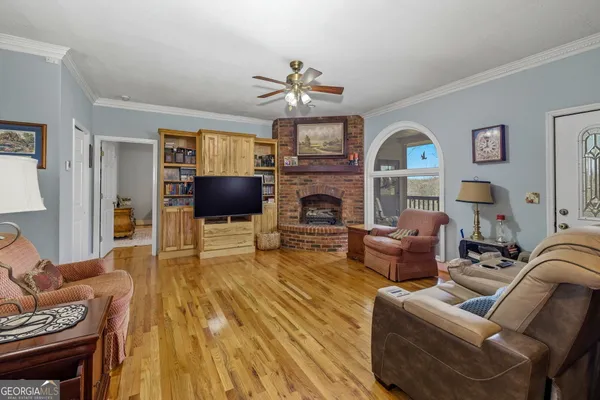 a kitchen with stainless steel appliances granite countertop a refrigerator a sink dishwasher a dining table and chairs with wooden floor