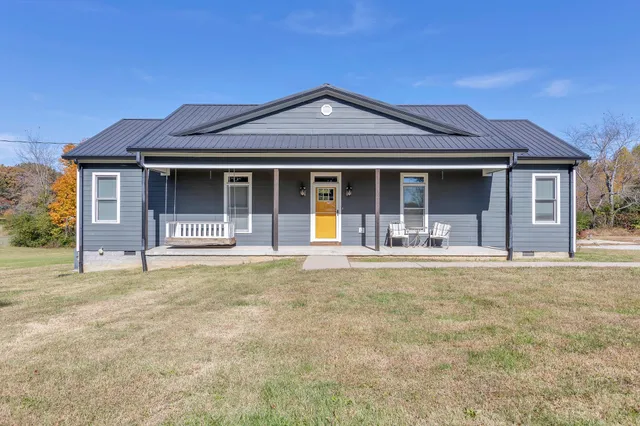 a view of a house with backyard and parking space