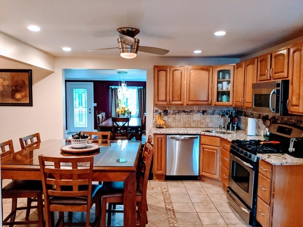 9 Byron Street Wakefield, MA 01880 - Photo 21 of 42 a kitchen with stainless steel appliances granite countertop a stove top oven a sink a stove a dining table and chairs