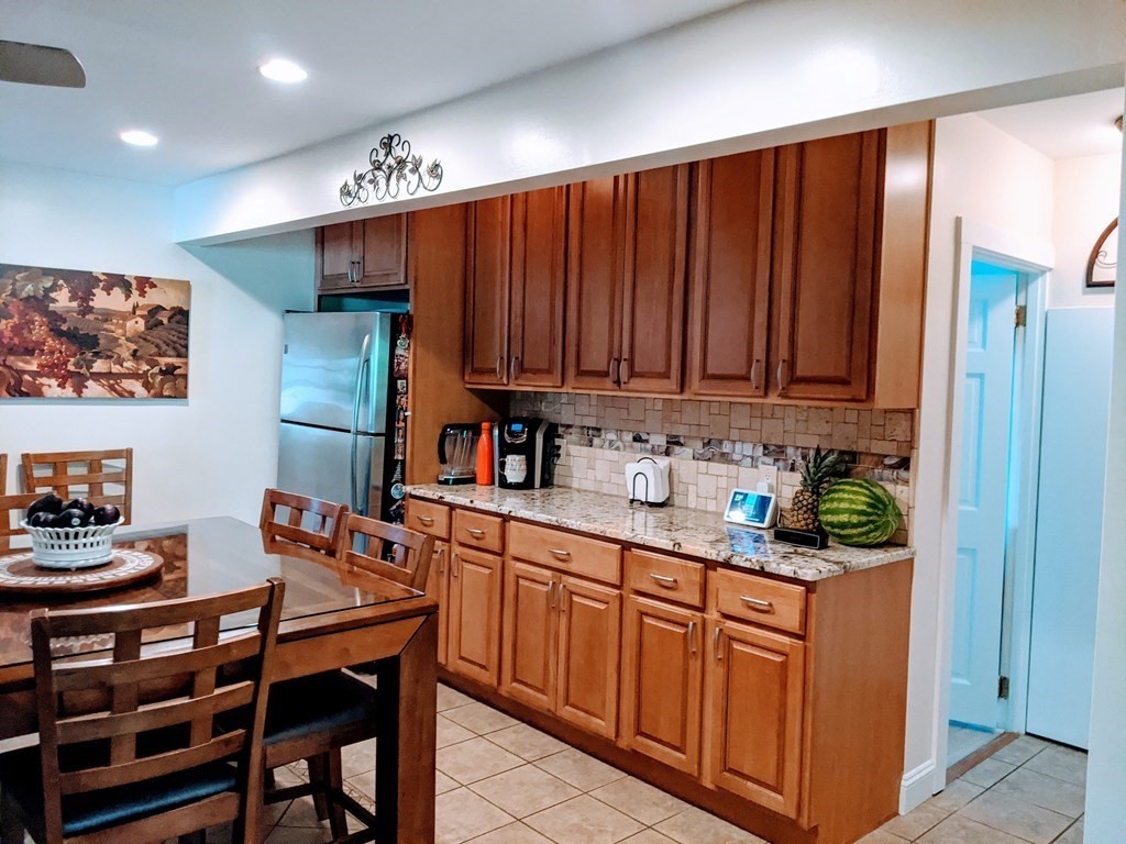 9 Byron Street Wakefield, MA 01880 - Photo 22 of 42 a kitchen with stainless steel appliances granite countertop a refrigerator and a wooden cabinets