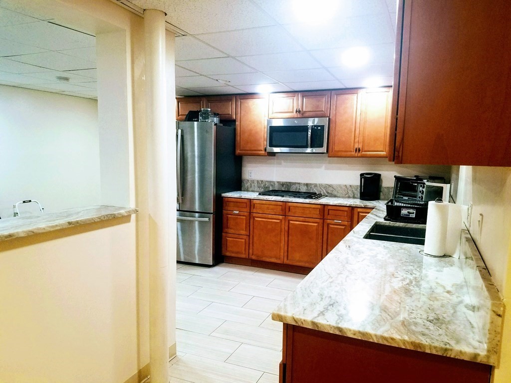 9 Byron Street Wakefield, MA 01880 - Photo 41 of 42 a kitchen with stainless steel appliances granite countertop a sink counter space and cabinets