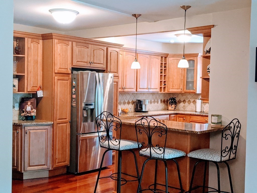 9 Byron Street Wakefield, MA 01880 - Photo 8 of 42 a dining room with stainless steel appliances granite countertop a dining table chairs refrigerator and sink