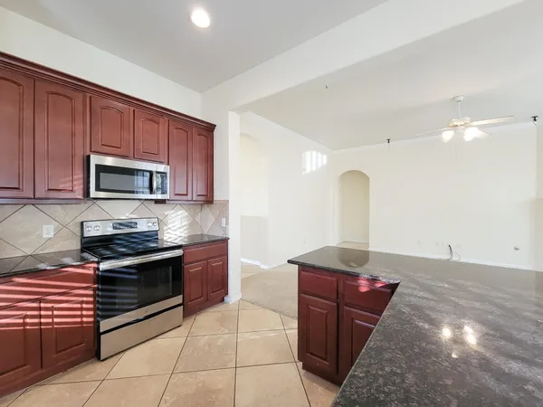a kitchen with stainless steel appliances granite countertop a stove a sink and a microwave