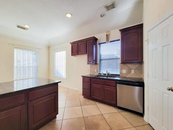 a kitchen with granite countertop cabinets and window