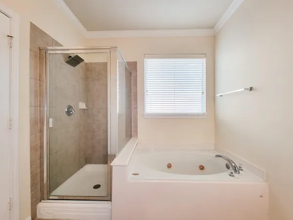 a bathroom with a tub a window and a shower