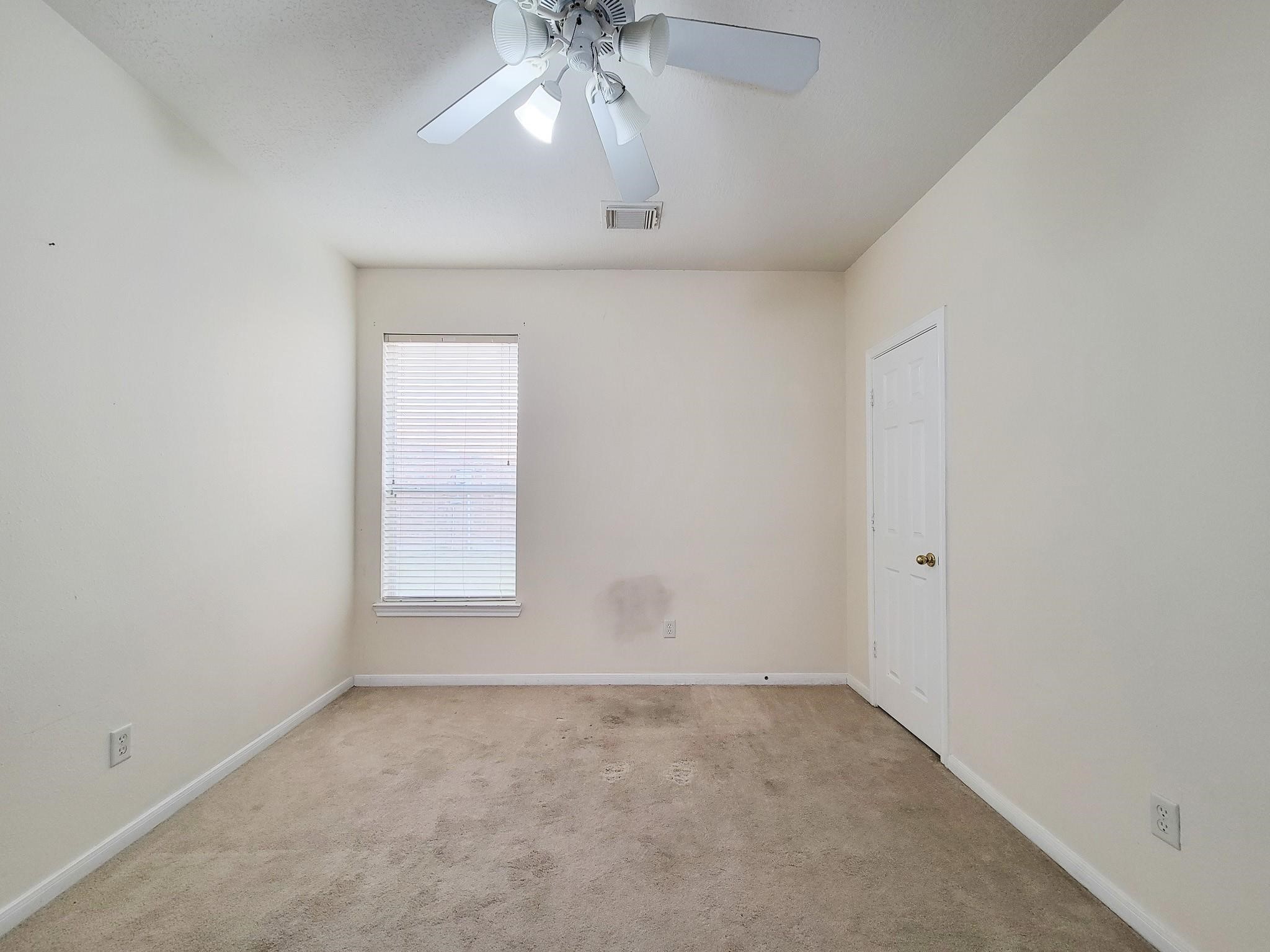 13935 Charterhouse Way Sugar Land, TX 77498 - Photo 24 of 36 an empty room with a chandelier fan and windows