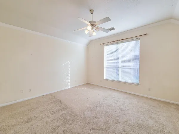 an empty room with windows and fan