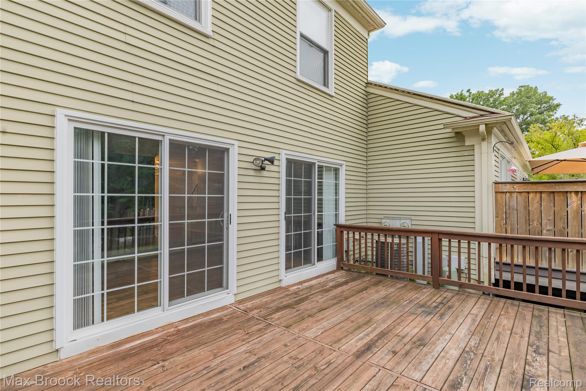 1157 Pine Ridge Court Rochester, MI 48306 - Photo 45 of 55 Spacious composite deck featuring rich wood-finish decking, black metal railings, and multiple French doors with gridded glass panes opening to the outdoor living area