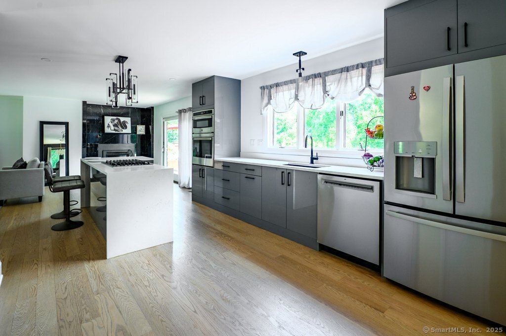 78 Blue Hills Road North Haven, CT 06473 - Photo 13 of 40 a kitchen with stainless steel appliances granite countertop a refrigerator a stove top oven a sink dishwasher and white cabinets with wooden floor