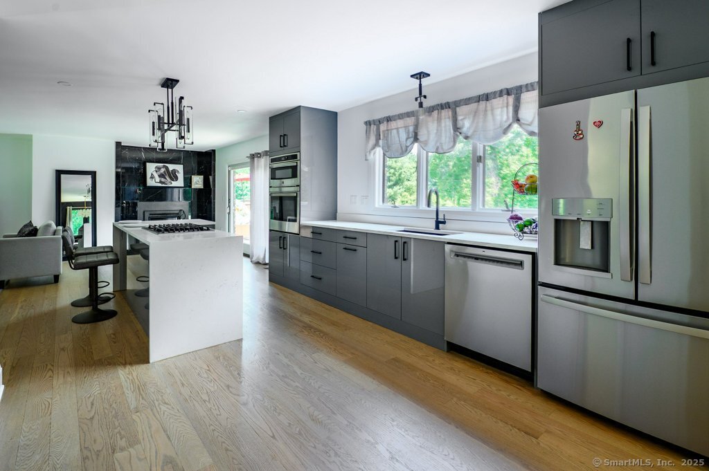 78 Blue Hills Road North Haven, CT 06473 - Photo 14 of 40 a kitchen with stainless steel appliances granite countertop a refrigerator a stove top oven a sink dishwasher and white cabinets with wooden floor