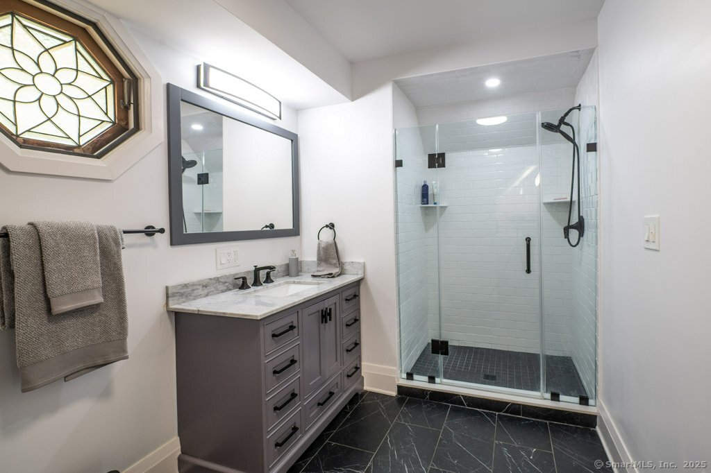 78 Blue Hills Road North Haven, CT 06473 - Photo 39 of 40 a bathroom with a sink a mirror and a shower