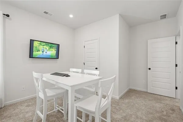 a patio with table and chairs and potted plants