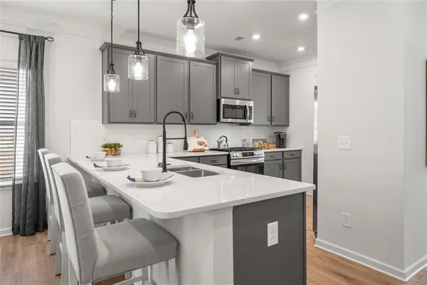 a living room with furniture a chandelier and kitchen view