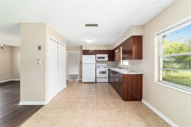 a large kitchen with a refrigerator and window