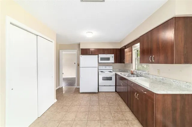 a large kitchen with a stove a refrigerator and a sink