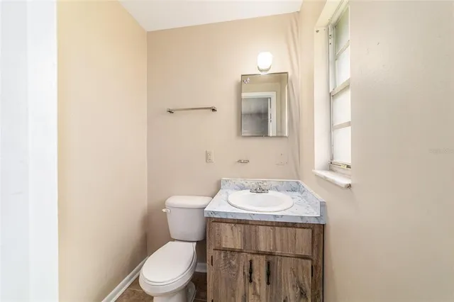 a bathroom with a toilet a sink and a mirror