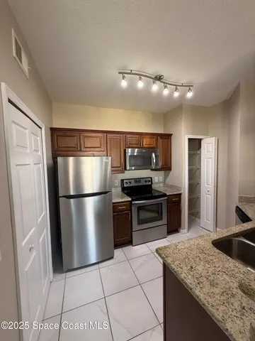 a kitchen with stainless steel appliances granite countertop a refrigerator and a sink