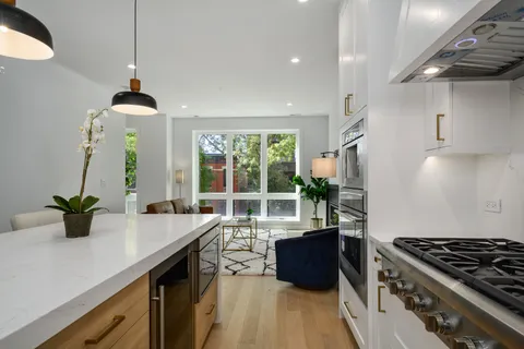 a kitchen with a stove and a wooden floor