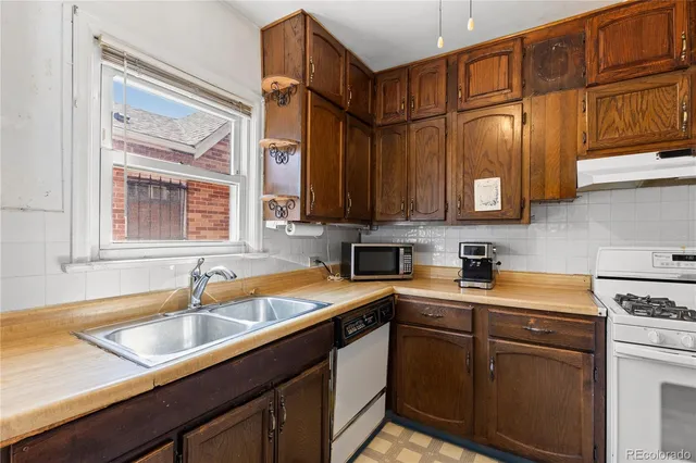 a kitchen with stainless steel appliances granite countertop a sink a stove and cabinets