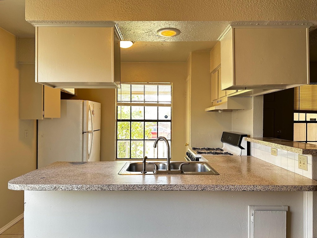 1102 Hickory Grove Drive, Unit B Austin, TX 78753 - Photo 5 of 14 a kitchen with granite countertop a sink and a window